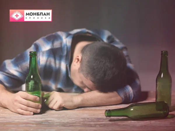 Нуждающийся в капельнице от запоя мужчина опустил голову с бутылкой в руке